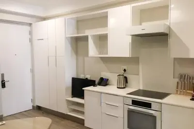 a kitchen with white cabinets and a stove at Regency Apartment Hotel Menlyn in Pretoria