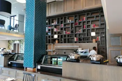 a restaurant kitchen with a chef preparing food at Regency Apartment Hotel Menlyn in Pretoria