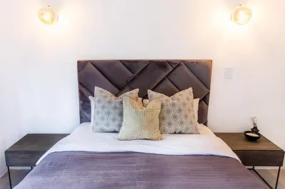 a bedroom with a bed with a wooden headboard and pillows at Waterfront Serenity View in Hartbeespoort