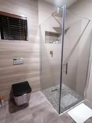 a bathroom with a shower with a glass door at HWH Guesthouse Middelburg in Middelburg