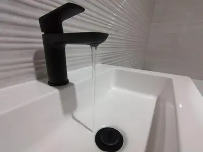 a black faucet on a white sink in a bathroom at HWH Guesthouse Middelburg in Middelburg