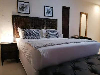 a bedroom with a large white bed with two pictures on the wall at HWH Guesthouse Middelburg in Middelburg