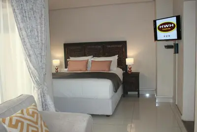 a bedroom with a bed and a television in it at HWH Guesthouse Middelburg in Middelburg