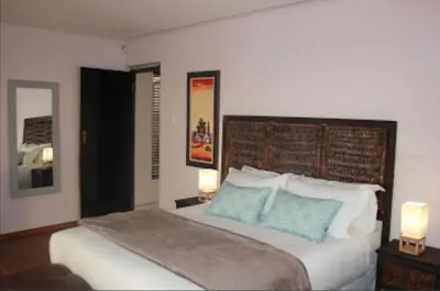 a bedroom with a large bed with two lamps on tables at HWH Guesthouse Middelburg in Middelburg