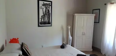a bedroom with two white beds and a door at Lovely holiday home for a large family or friends bordering Kruger National Park in Marloth Park