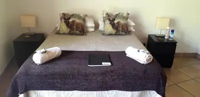 a bedroom with a bed with a tablet on it at Lovely holiday home for a large family or friends bordering Kruger National Park in Marloth Park