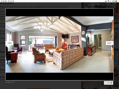 a living room with a couch and a table and chairs at Rueby’s Guesthouse in Dullstroom