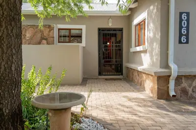 a door to a building with a table in front of it at Rueby’s Guesthouse in Dullstroom