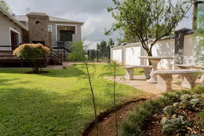 a backyard with a picnic table and a bench at Rueby’s Guesthouse in Dullstroom