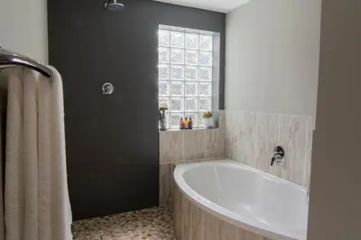 a bathroom with a bath tub and a window at Rueby’s Guesthouse in Dullstroom