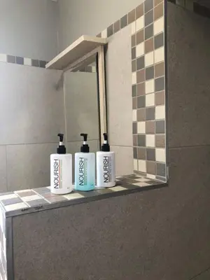 three bottles ofodorizers sitting on a shelf in a bathroom at Rueby’s Guesthouse in Dullstroom