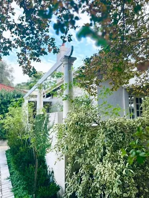 a white fence in front of a white house at Middelberg Manor in Pretoria
