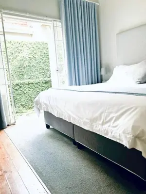 a bedroom with a bed and a large window at Middelberg Manor in Pretoria