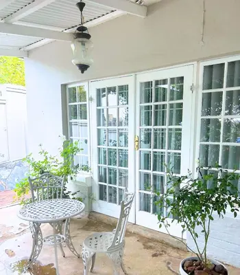 a patio with a table and chairs on a porch at Middelberg Manor in Pretoria