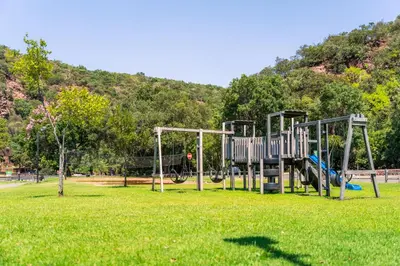 a playground in a park with green grass at ATKV Klein-Kariba in Bela-Bela