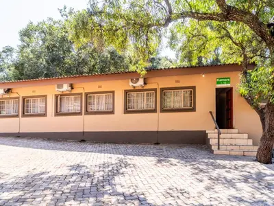 a building with a tree in front of it at ATKV Klein-Kariba in Bela-Bela