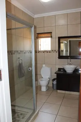 a bathroom with a shower and a toilet and a sink at ATKV Klein-Kariba in Bela-Bela