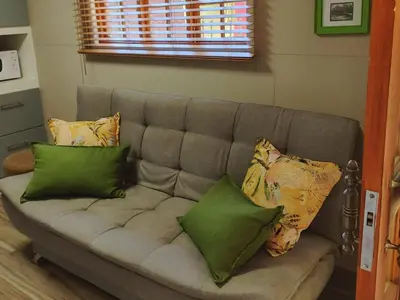 a couch with pillows on it in a living room at Sarah's Place Guesthouse in Pretoria