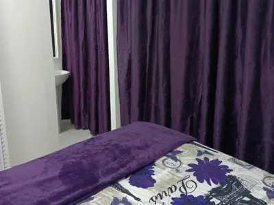a bed with a purple blanket on top of it at Sarah's Place Guesthouse in Pretoria