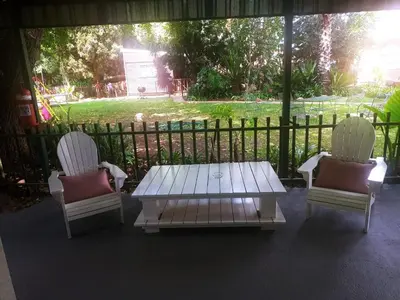 two chairs and a coffee table on a porch at Sarah's Place Guesthouse in Pretoria