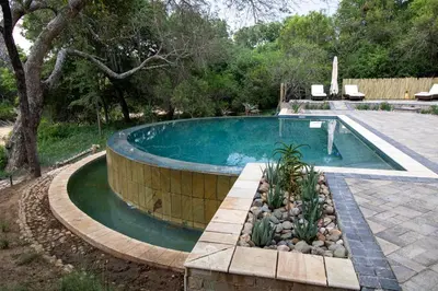 a swimming pool in a yard with a landscaping at Little Africa Safari Lodge in Hoedspruit
