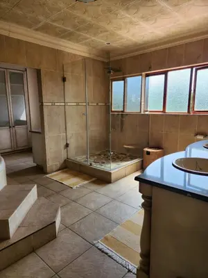 a large bathroom with a shower and a sink at Fhamoni House in Centurion