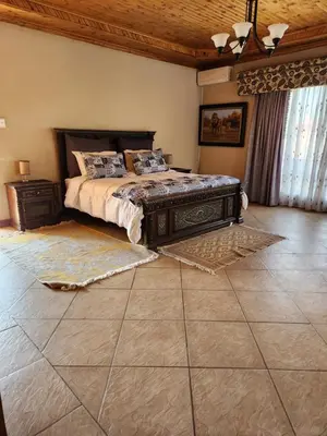 a bedroom with a bed and a tiled floor at Fhamoni House in Centurion