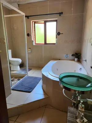 a bathroom with a tub and a toilet at Fhamoni House in Centurion