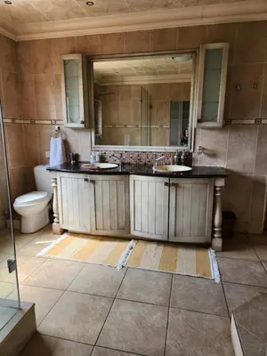 a bathroom with two sinks and a toilet at Fhamoni House in Centurion