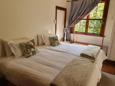 a bedroom with two beds and a window at Skye High House & Cottage in Dullstroom