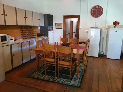 a kitchen with a table and chairs and a refrigerator at Skye High House & Cottage in Dullstroom