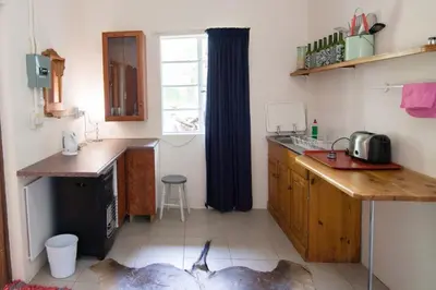 a kitchen with a counter and a sink and a window at Skye High House & Cottage in Dullstroom
