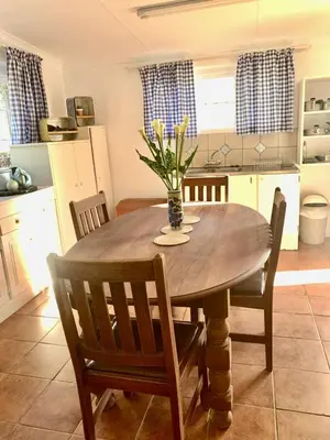 a dining room table with a vase of flowers on it at Rondebossie Farm Retreat in Magoebaskloof