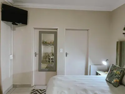 a bedroom with a bed and a mirror at Rondebossie Farm Retreat in Magoebaskloof