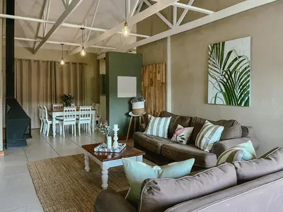 a living room with two couches and a table at Rondebossie Farm Retreat in Magoebaskloof