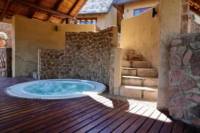 a hot tub on the deck of a house at Schrikkloof Private Nature Reserve, home of The Lions Foundation in Bela-Bela