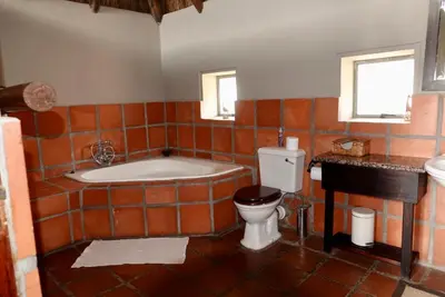 a bathroom with a tub and a toilet and a sink at Schrikkloof Private Nature Reserve, home of The Lions Foundation in Bela-Bela