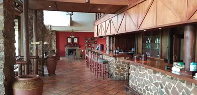 a bar in a restaurant with red walls at Schrikkloof Private Nature Reserve, home of The Lions Foundation in Bela-Bela