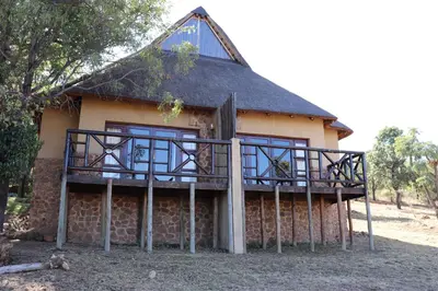 a house with a large deck in front of it at Schrikkloof Private Nature Reserve, home of The Lions Foundation in Bela-Bela