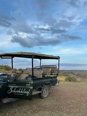 a green vehicle parked in the middle of a field at Schrikkloof Private Nature Reserve, home of The Lions Foundation in Bela-Bela