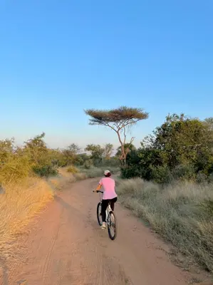 a person riding a bike down a dirt road at Little Kubu Lodge in Hoedspruit