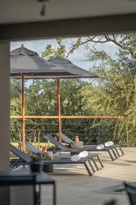a group of tables with umbrellas on a patio at Little Kubu Lodge in Hoedspruit