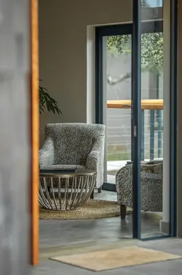 a living room with a chair and a mirror at Little Kubu Lodge in Hoedspruit