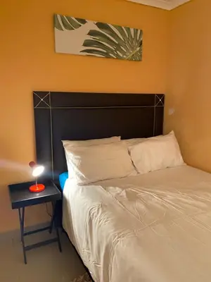 a bedroom with a bed and a night stand with a lamp at Mankweng lodge in Polokwane