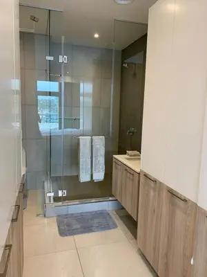 a bathroom with a glass shower and a sink at Menlyn Maine Trilogy 11th Floor in Pretoria