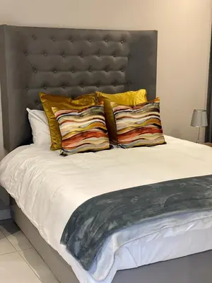 a bedroom with a large bed with yellow pillows at Menlyn Maine Trilogy 11th Floor in Pretoria