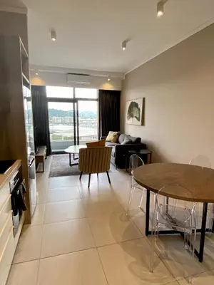 a living room with a table and a couch at Menlyn Maine Trilogy 11th Floor in Pretoria