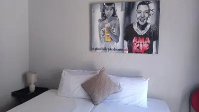 a bedroom with a white bed with a picture on the wall at Dumelang Executive Lodge- OFF-GRID Solar powered Midrand in Midrand