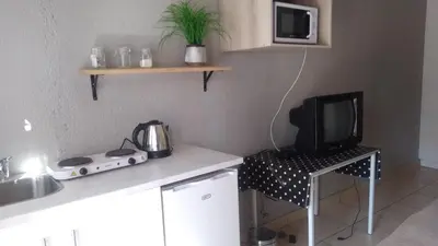 a small kitchen with a tv and a table with a microwave at Dumelang Executive Lodge- OFF-GRID Solar powered Midrand in Midrand