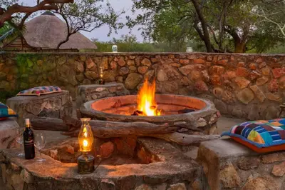 a fire pit in a stone wall with two bottles at No 43 - The Eco Lodge in Hoedspruit